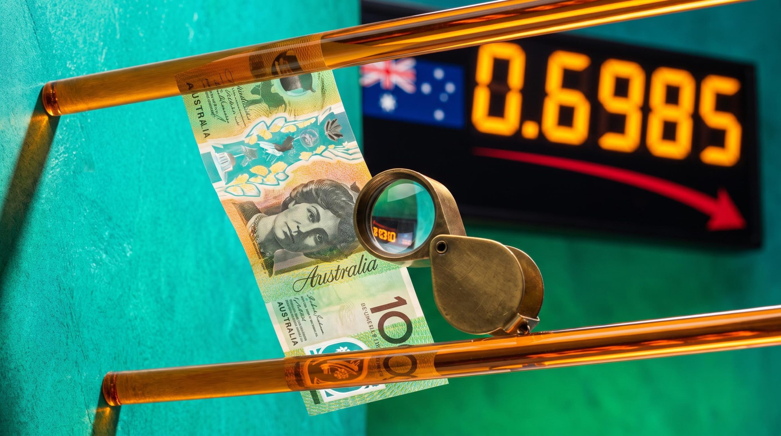 AUD/USD outlook: Australian banknote under a loupe before a trading board showing the 0.6985 resistance level