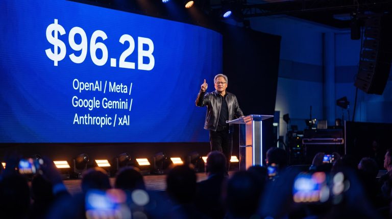 Jensen Huang on stage at All-In Summit with $96.2B Nvidia revenue figure displayed behind him