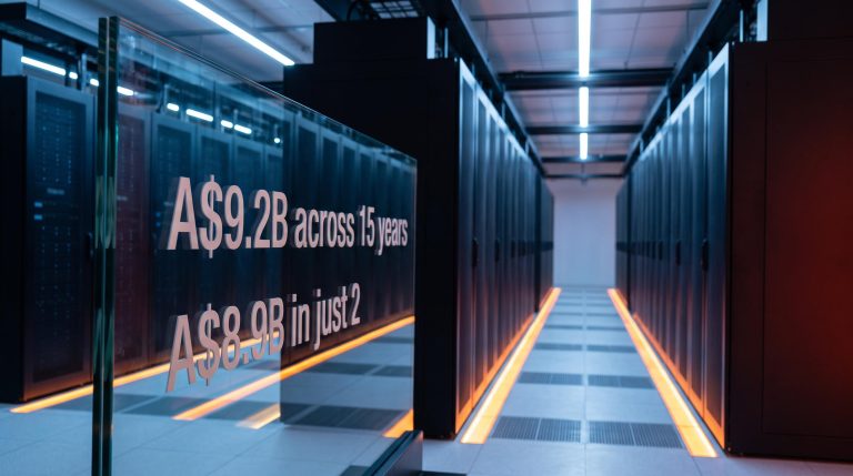 NextDC data centre hall with A$9.2B vs A$8.9B capex comparison rendered on illuminated glass panel