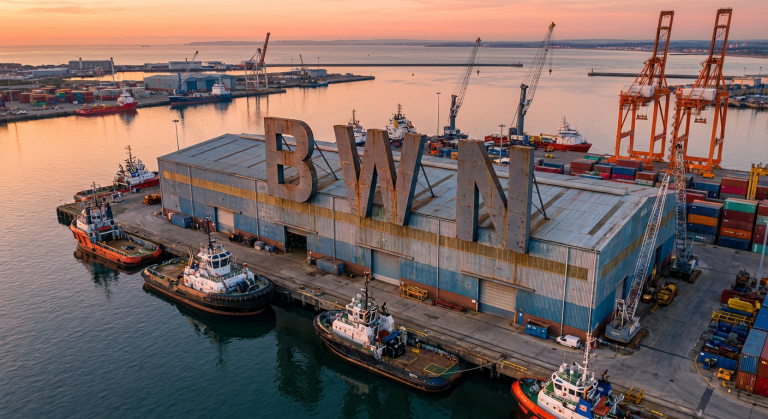 Docked tugboats by warehouse
